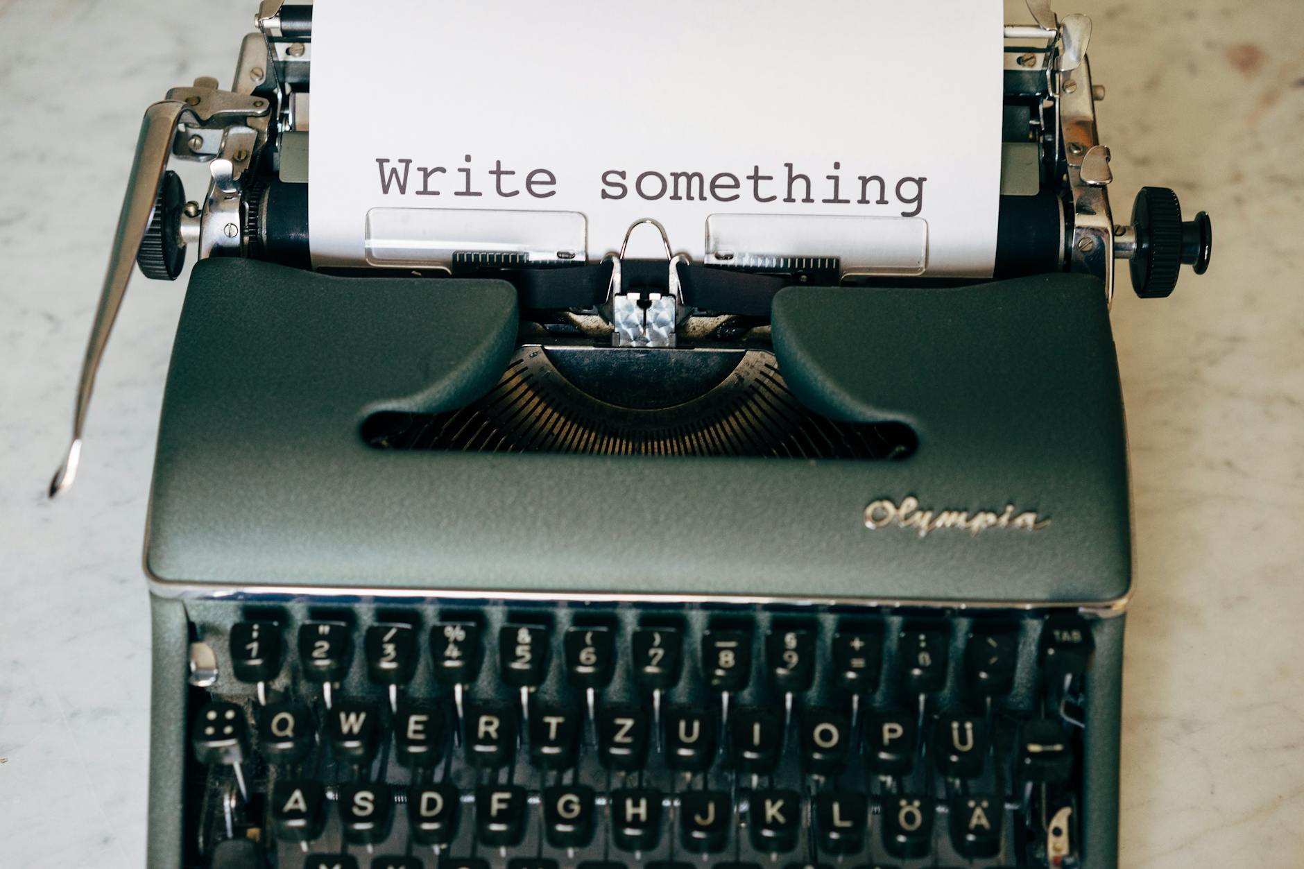 Classic typewriter displaying 'Write something' on paper. Perfect for creative inspiration.