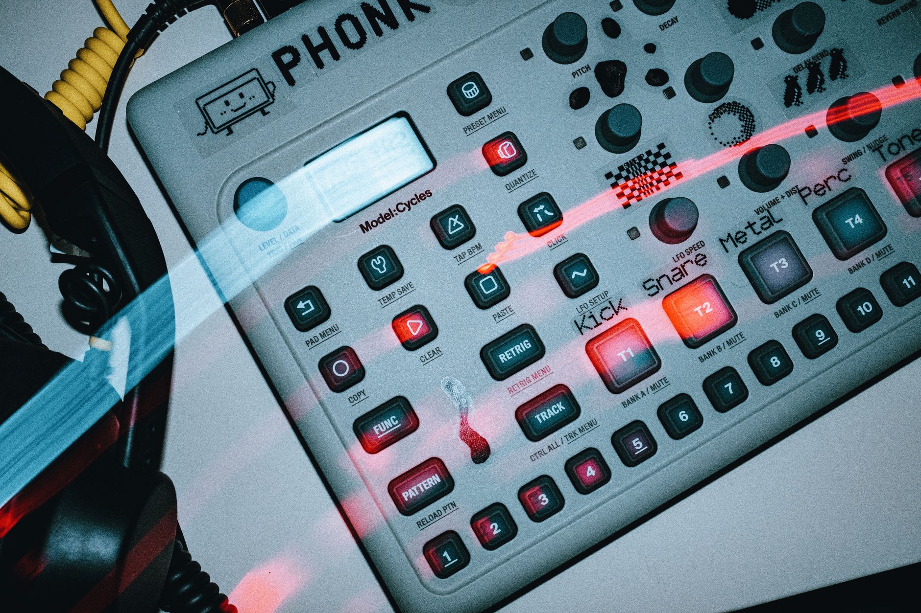 Close-up of a synthesizer console with glowing buttons and retro design.