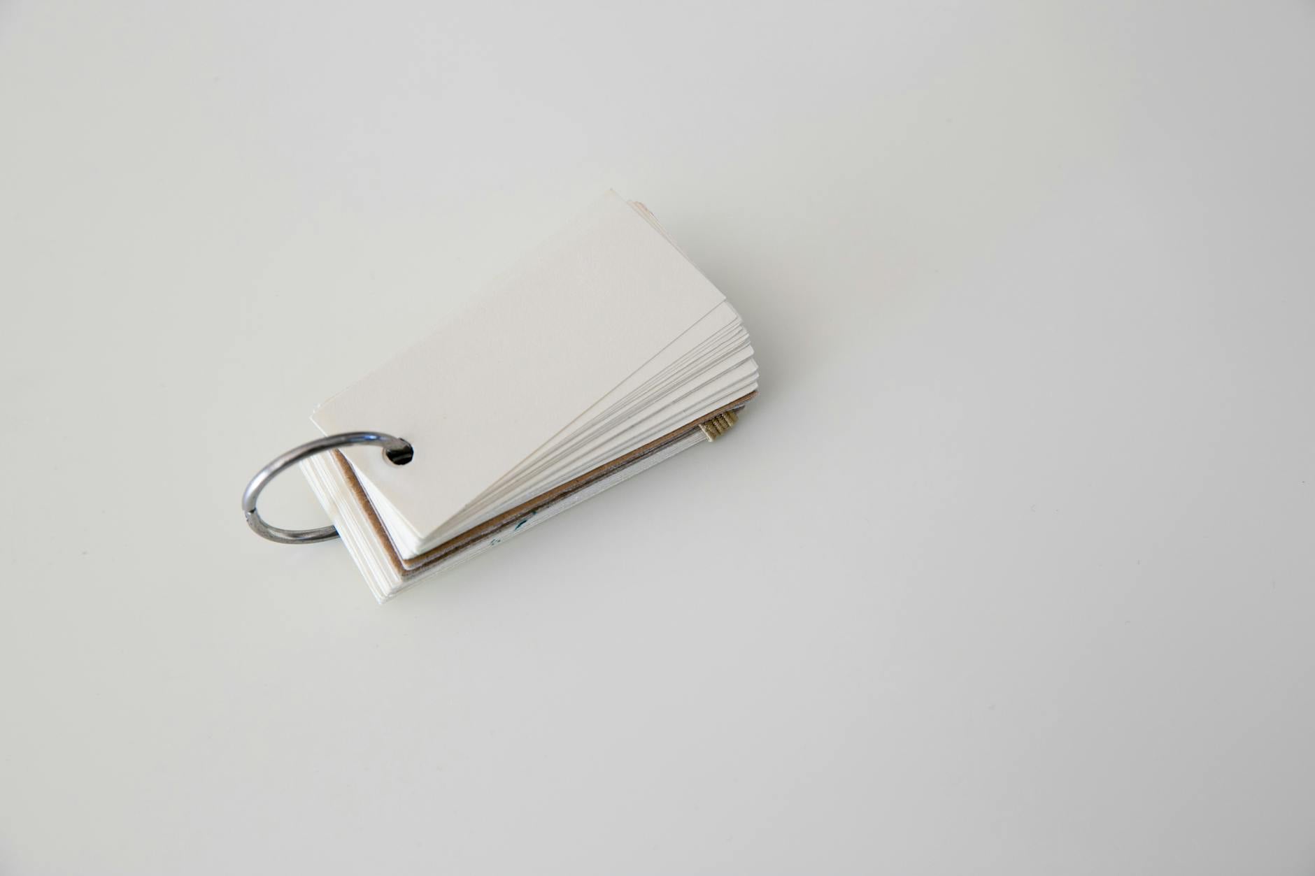 Blank flashcards on a white background held together by a metal ring, perfect for study or organization.
